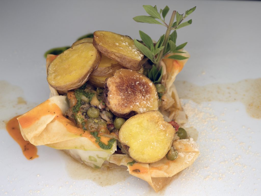 Ropa vieja de pulpo con papas bonitas sobre oblea crujiente